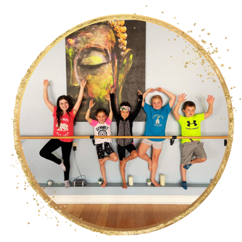 Group of children posing with a ballet barre, colorful Buddha painting in background
